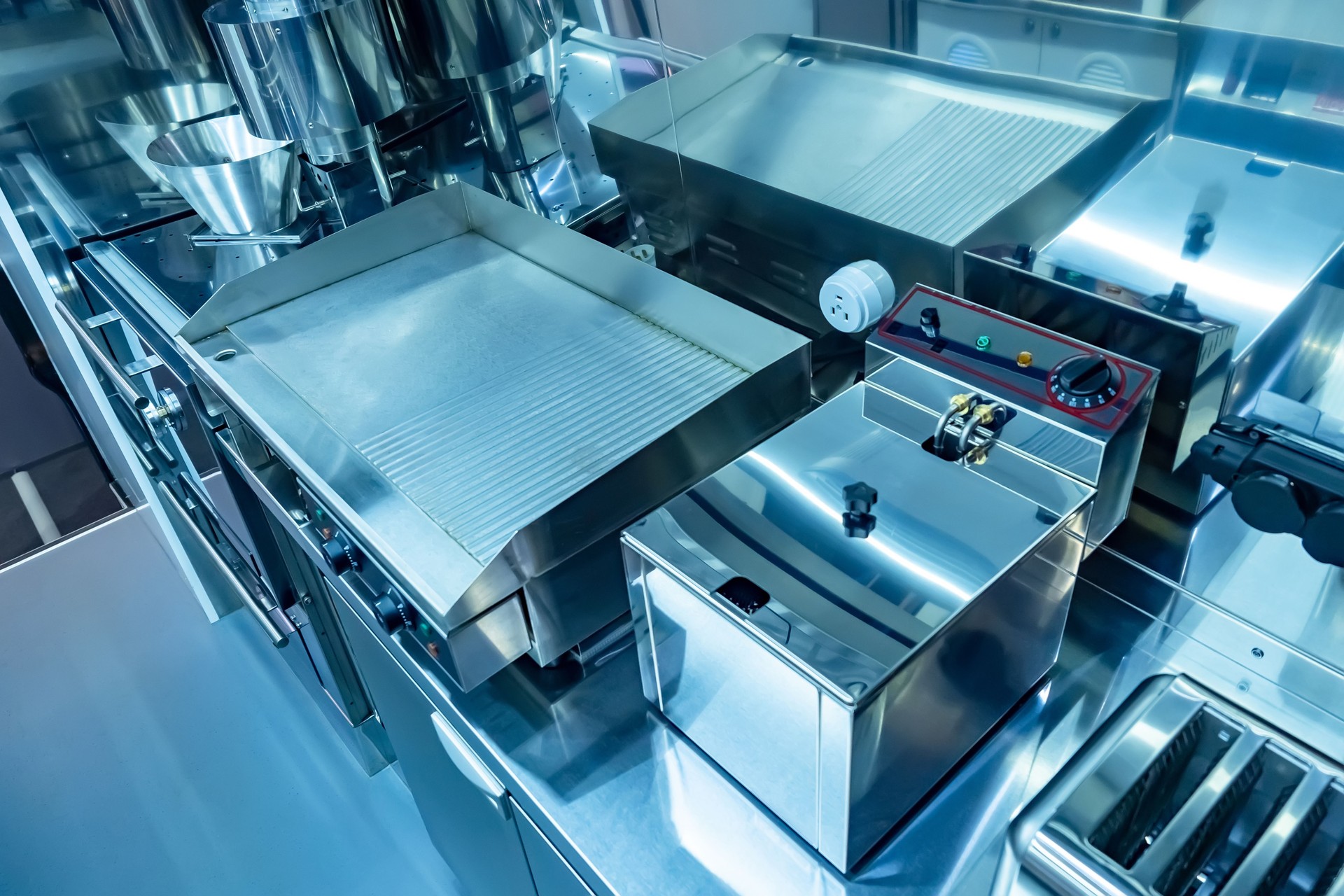 Cuisine of the restaurant. Concept - restaurant cleaning services. Purity. Equipment for food production. Equipment for restaurants. Electric frying pan top view. Toaster. Deep fryer in a cafe.
